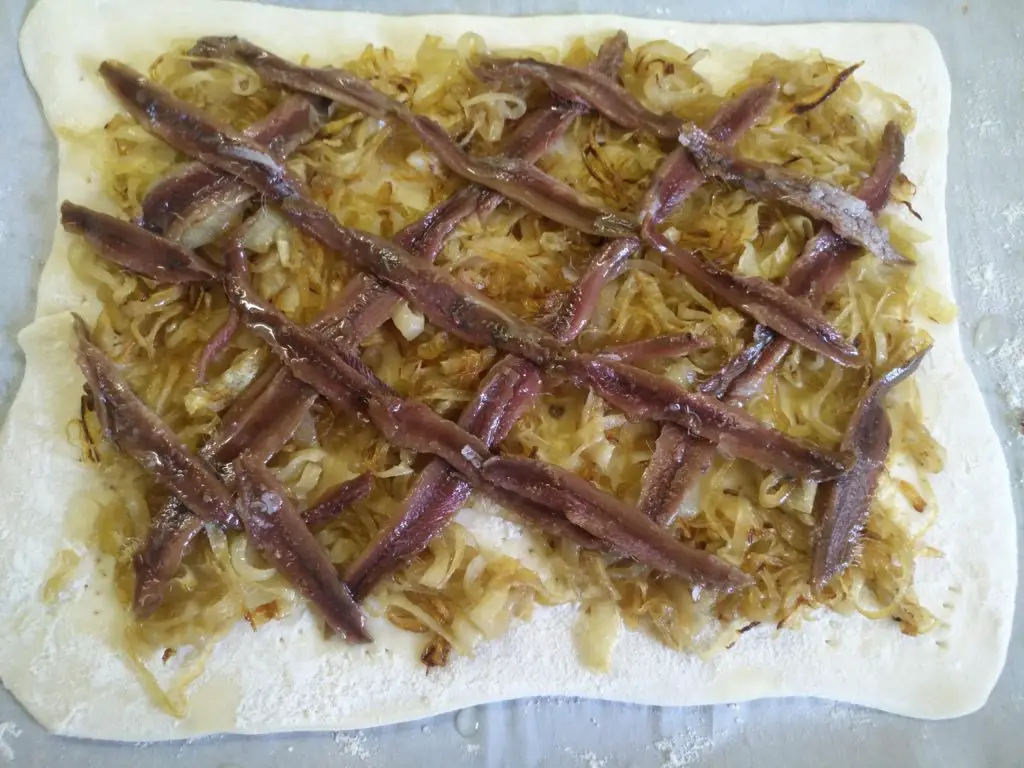 unbaked pissaladiere with caramelized onions and anchovies