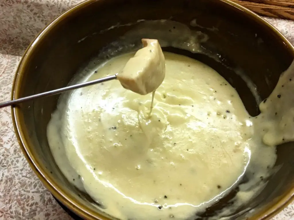 dipping bread into cheese fondue