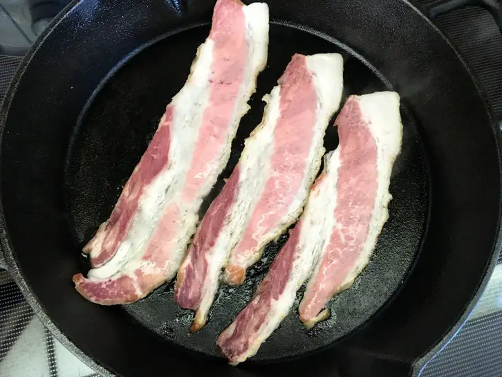 cooking bacon in a cast iron skillet
